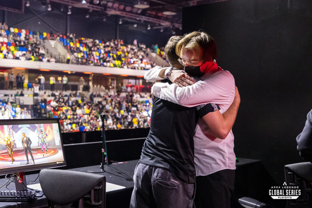 An esports player and their coach embrace after winning a game in the Apex Legends Global Series